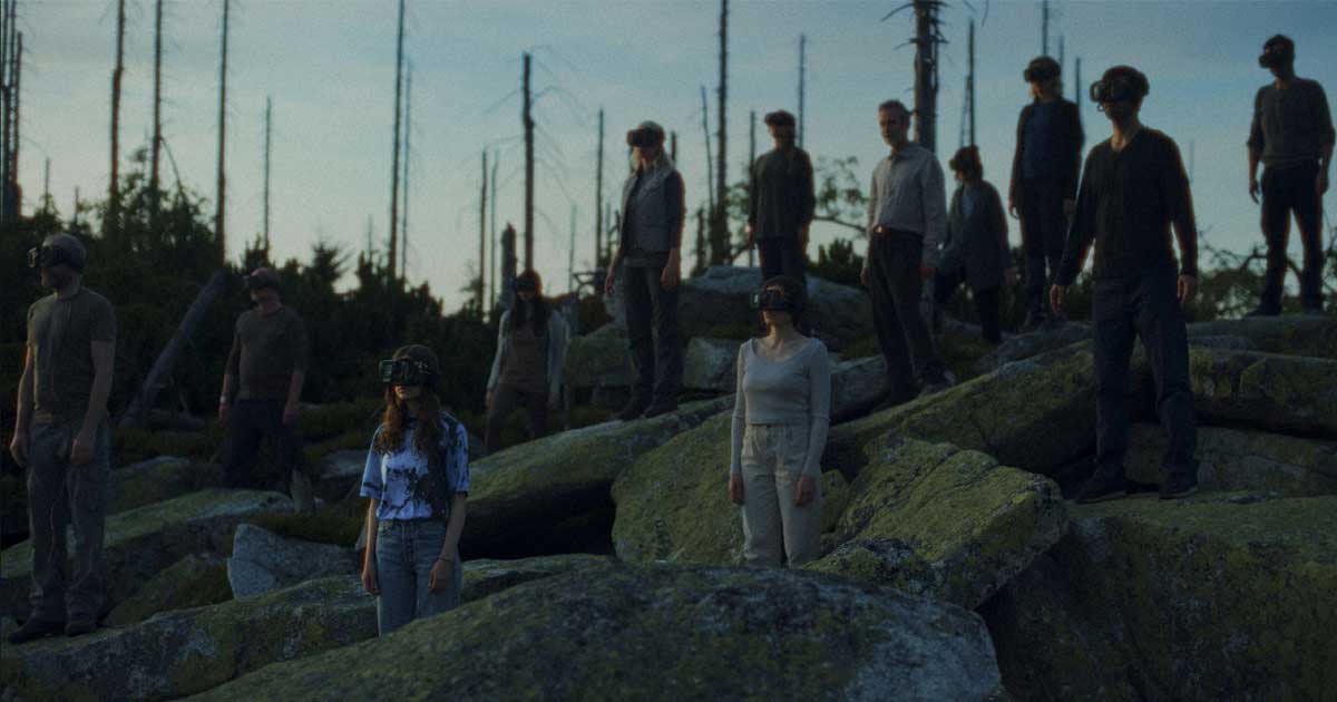 The cast of the film Jupiter, wearing virtual reality headsets, and standing in a rocky area.
